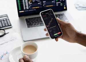 Coronavirus, image of a hand holding a cellphone showing stock market app