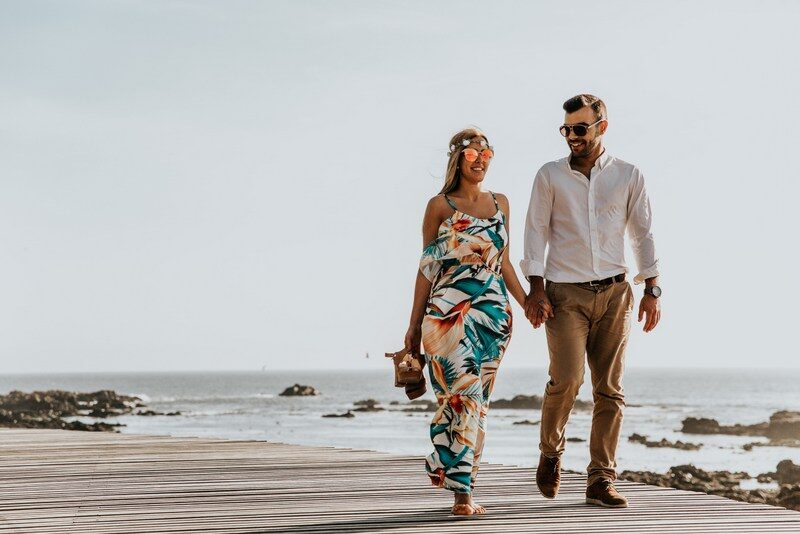 happy relationship, couple holding each other while walking at the beach