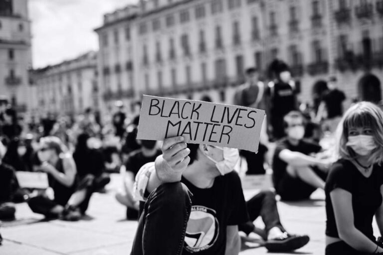 Inequality, a man holding cards with "black lives matter"