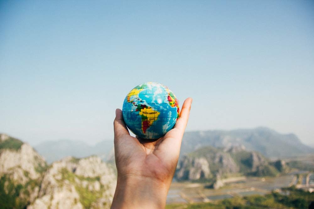 Inequality, a hand holding a world globe