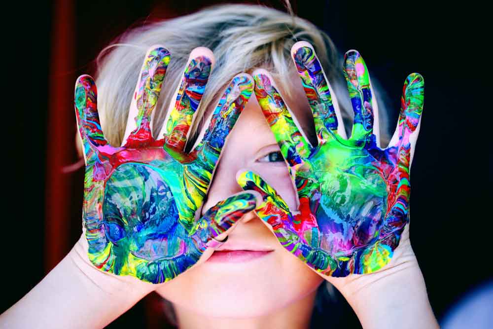 Art therapy, a Kid With Multicolored Hand Paint
